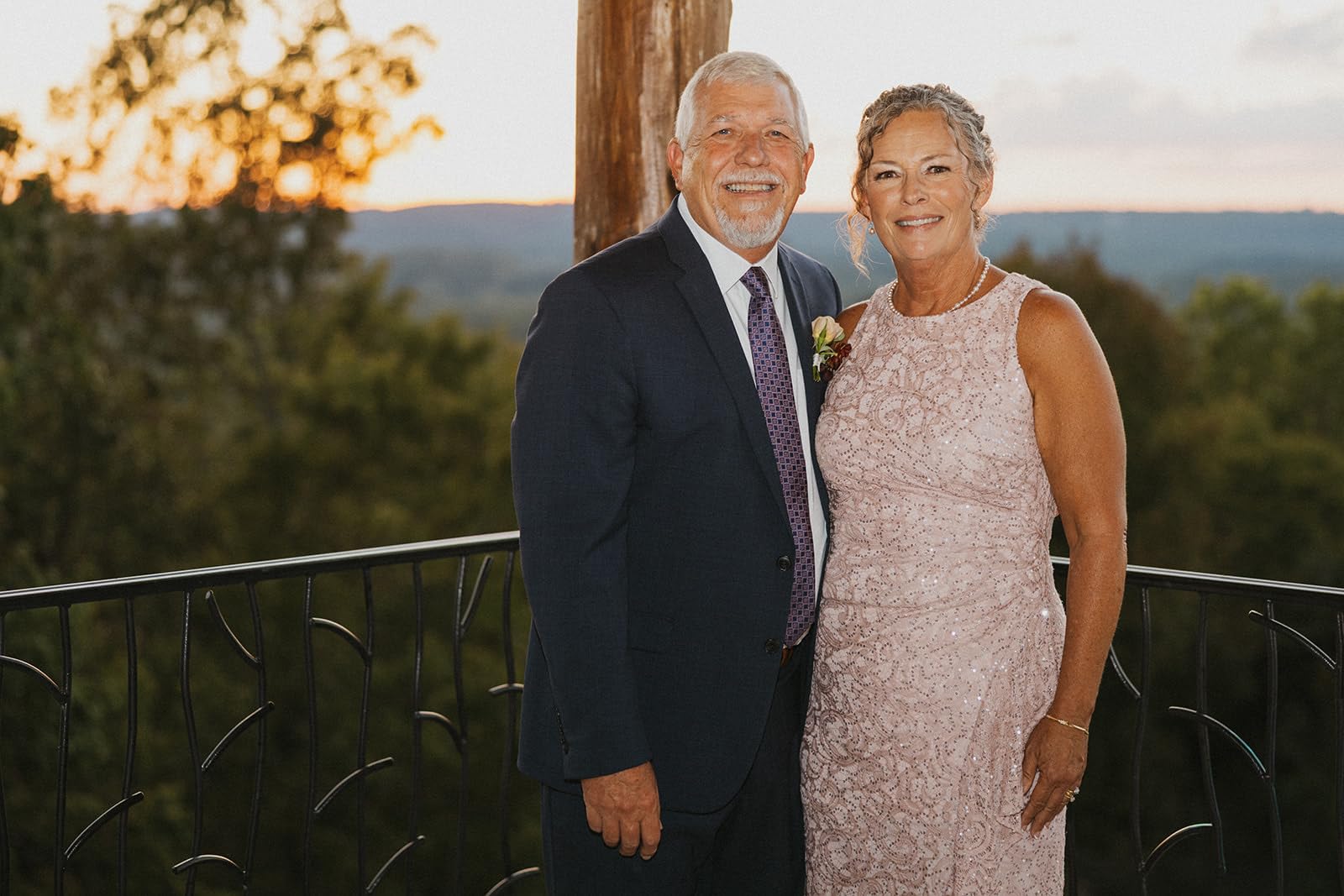 Mother of the bride wearing a blush sequin dress with husband during an outdoor mountain wedding