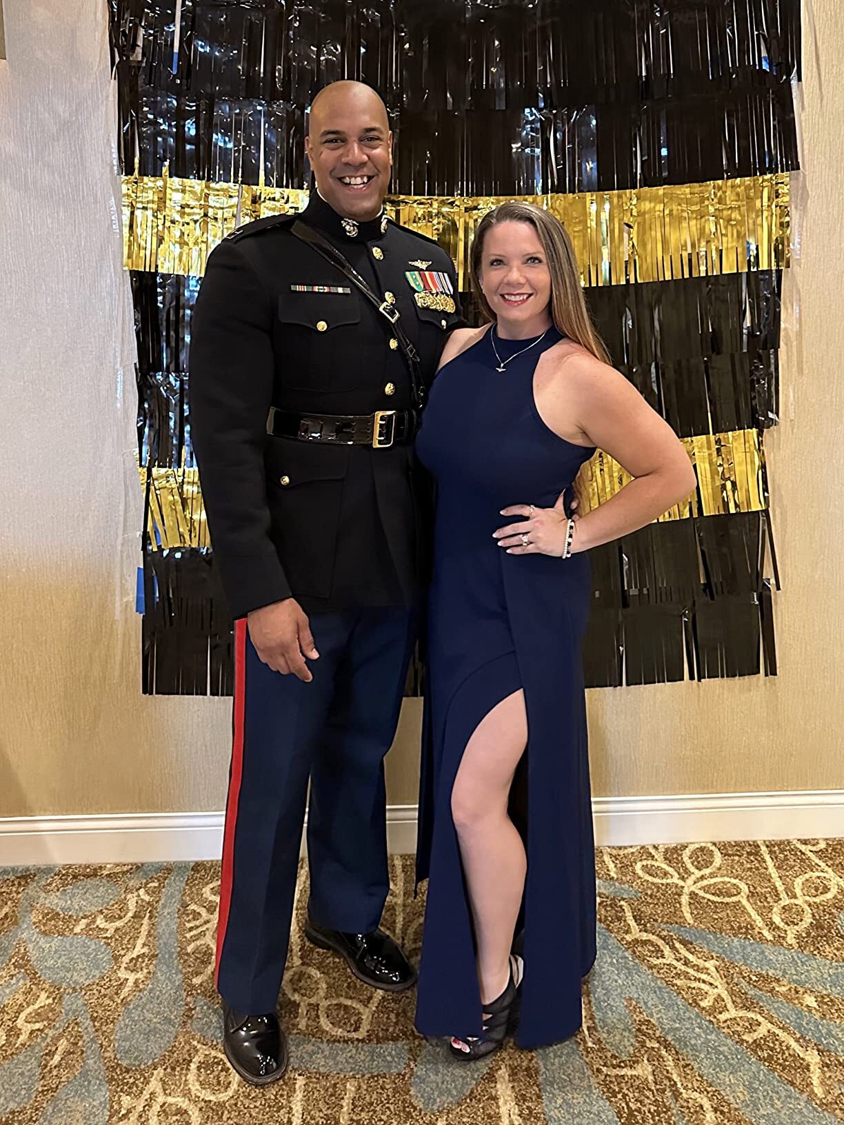 Couple posing at a Marine Corps Ball with woman wearing a navy formal gown