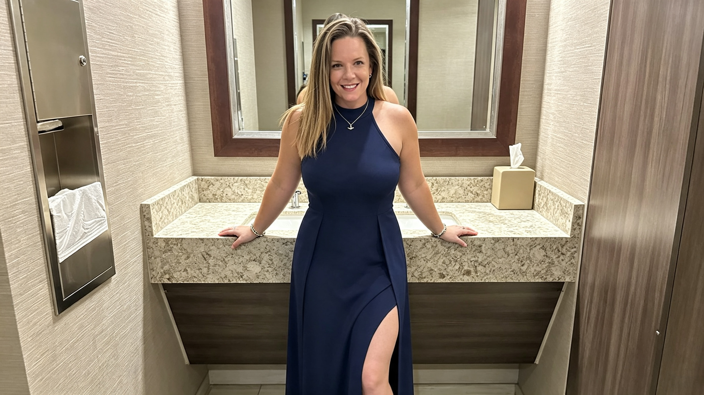 Mirror selfie showing the high slit and fit of a navy maxi formal dress