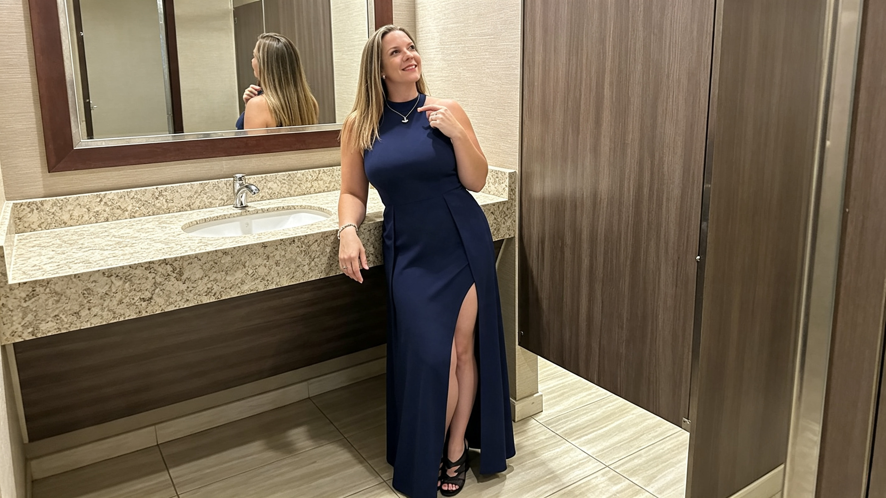 Full length mirror photo of a woman wearing a navy halter maxi dress for a formal event